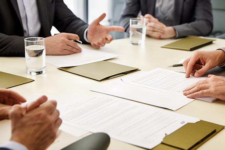 Reunión profesional sobre un contrato mercantil con documentos societarios sobre la mesa